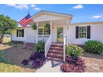 Charming single-story home with brick stairs, white siding, and an inviting front porch decorated with an American flag at 4408 Robins Nest Rd, Concord, NC 28027