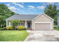 Charming single-Gathering home with a well-manicured lawn, covered porch, and attached garage, perfect for comfortable suburban living at 7106 Kinsmore Ln, Charlotte, NC 28269