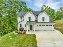 Beautiful white two-story home with a two car garage and beautifully manicured flower beds at 8136 Energy Ln, Catawba, NC 28609