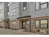 Modern townhome featuring a stylish brick facade with a gray and white color scheme at 834 Van Every St, Charlotte, NC 28205