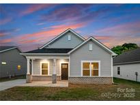 Charming single-story home with gray siding, brick accents, and a cozy front porch at 1619 Martin Ave, Gastonia, NC 28052