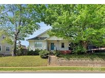 Charming single-story home with a blue front door, mature trees, and landscaped front yard at 209 S Ransom St, Gastonia, NC 28052