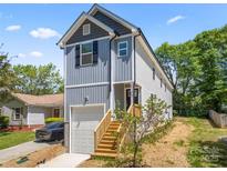 Charming two-story home boasts a gray exterior with a garage and inviting wooden steps at 3205 Morning Dr, Charlotte, NC 28208