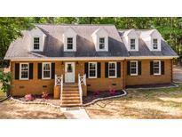 Charming brick home featuring a classic design with black shutters and a well-manicured front yard at 328 Earl Griffin Rd, Monroe, NC 28112