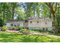 Charming two-story home with grey siding, red door, beautiful landscaping, and mature trees at 3329 Winnipeg Cir, Charlotte, NC 28210