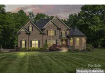 Charming two-story brick home featuring manicured landscaping and a welcoming front entrance with a turret at 3398 Millstone Creek Rd, Lancaster, SC 29720