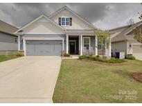 Charming home featuring a two-car garage, inviting front porch, and manicured lawn at 4027 Gozzi Dr, Iron Station, NC 28080