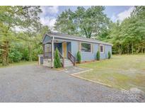 Charming blue single-Gathering home featuring a gravel driveway and inviting front porch at 405 Belva St, Kannapolis, NC 28081
