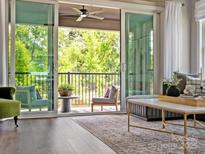 Bright living room features a view of the balcony with ceiling fan and outdoor chairs at 411 Old Town Village Rd, Waxhaw, NC 28173