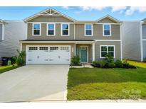 Two-story home featuring neutral siding, a two-car garage, and a well-manicured lawn at 4439 Wild Ridge Dr, Charlotte, NC 28215