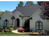 Charming single-story home featuring a beautifully landscaped yard, arched doorway and black trimmed windows at 7280 Woodside Ct, Denver, NC 28037