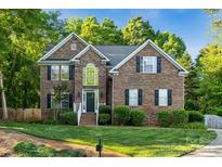 Charming two-story brick home with black shutters and lush green landscaping at 817 Quince Ct, Indian Trail, NC 28079