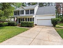 Charming two-story home with a well-manicured lawn, a two car garage and a welcoming front porch at 9101 Strattonville Ct, Huntersville, NC 28078