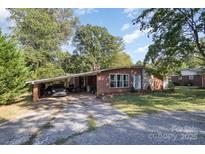Cozy brick home with mature trees, covered carport, and a well-maintained front yard at 1239 Christopher Cir, Rock Hill, SC 29730