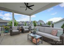 Inviting covered patio featuring comfortable seating, ceiling fan, and neighborhood views, perfect for outdoor relaxation at 13624 Jacks Ln, Pineville, NC 28134