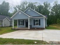 Charming single-story home featuring a welcoming front porch and a well-manicured lawn at 225 Baker St, Rock Hill, SC 29730