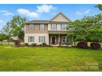 Charming two-story home with a well-manicured lawn and inviting front porch, surrounded by lush landscaping at 4506 S Potter Rd, Monroe, NC 28112
