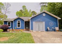 Charming blue single-story home with well-maintained lawn and a cozy front patio area at 4810 Shea Ct, Monroe, NC 28110