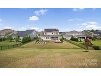 Fenced backyard with a patio, hot tub, vegetable garden, and a play area at 528 Rock Skip Way, Fort Mill, SC 29708