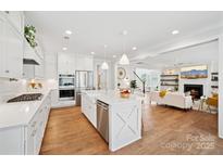 Bright, open kitchen with white cabinets, stainless steel appliances, and a large island at 528 Rock Skip Way, Fort Mill, SC 29708