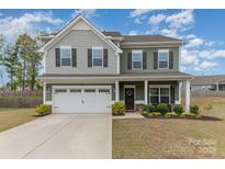 Charming two-story home with a well-manicured lawn, attached garage and beautiful landscaping at 6070 Trinity Crossing Cir, Kannapolis, NC 28081