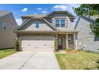 Charming two-story home featuring a stone facade, a two-car garage, and a well-maintained front lawn at 726 Centennial St, Gastonia, NC 28056