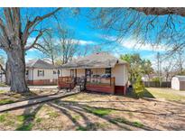 Charming single-story home featuring a inviting front porch, landscaped yard, and mature trees at 803 N Walnut St, Kannapolis, NC 28081
