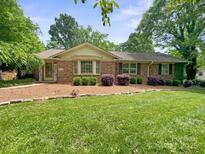 Charming single-story brick home with a well-manicured lawn and landscaped front yard at 828 N 6Th St, Albemarle, NC 28001