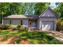 Charming one-story home with a well-manicured lawn, mature trees, and inviting front entrance at 901 Southland Rd, Huntersville, NC 28078