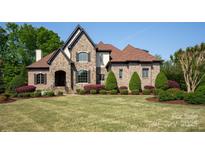 Beautiful stone and brick home with manicured lawn, lush landscaping, and a classic, timeless design at 1304 Lookout Cir, Waxhaw, NC 28173