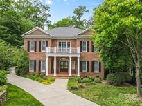 Elegant two-story brick home with a charming balcony and lush landscaping at 1806 Asbury Hall Ct, Charlotte, NC 28209