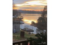 Picturesque lake view with a stunning sunset, private docks, and calm waters reflecting the colorful sky at 209 Woodstream Cir, Mooresville, NC 28117