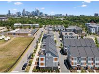 An aerial view of townhouses with a city skyline in the background on a bright sunny day at 2111 Isom St, Charlotte, NC 28208