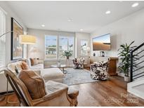Bright living room featuring hardwood floors, stylish furniture, and a large flat-screen TV for optimal comfort at 2111 Isom St, Charlotte, NC 28208