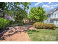 Charming brick home with lush landscaping, a brick walkway, and mature trees in a desirable neighborhood at 2125 Chatham Ave, Charlotte, NC 28205