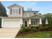 Charming two-story home featuring a covered front porch, attached garage and well-maintained landscaping at 2140 Majestic Poplar Dr, Waxhaw, NC 28173