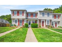 Charming townhome featuring a landscaped front yard and red shutters at 218 Water Oak Dr, Pineville, NC 28134