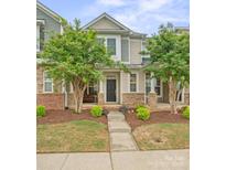 Charming two-story home with a well-manicured lawn and inviting front porch with stone accents and trees at 233 E Waterlynn Rd # B, Mooresville, NC 28117