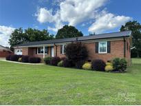 Charming one-story brick home with manicured lawn and black accent shutters at 396 Pitts School Nw Rd, Concord, NC 28027