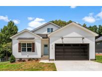 Charming exterior featuring a two-car garage, light blue front door, manicured lawn and craftsman-style details at 418 W Westview St, Gastonia, NC 28052