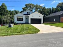 Charming single-Gathering home featuring a modern white facade, black garage door, and a well-manicured lawn at 418 W Westview St, Gastonia, NC 28052