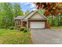 Charming single-story brick home with attached garage, landscaped yard, and mature trees at 4927 Gateway Dr, Claremont, NC 28610