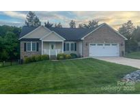 Charming brick and vinyl home with well-maintained lawn and attached two-car garage at 506 E Pine St, Maiden, NC 28650
