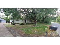 Charming single-story home with a covered front porch and mature trees providing shade at 5612 Henderson Cir, Charlotte, NC 28269