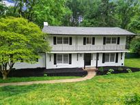 Charming two-story home with white brick, black shutters, and well-manicured front yard landscaping at 7531 Linda Lake Dr, Charlotte, NC 28215