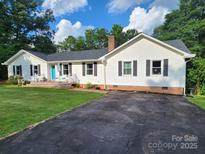 Charming home with a bright blue door, a cozy porch, and a spacious driveway at 854 Silver Fox Dr, Concord, NC 28025