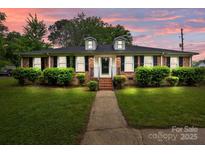 Charming brick home with well-manicured lawn and shrubbery, featuring dormer windows and a welcoming walkway at 101 Wynnchester Rd, Gastonia, NC 28056