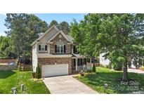 Beautiful two-story home featuring a brick facade, attached garage, and well-manicured front yard at 1011 Master Gunner Ct, Indian Trail, NC 28079