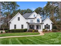 Beautiful white brick home with lush lawn and mature trees at 107 Waterhouse Ct, Mooresville, NC 28117