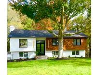 Charming exterior featuring manicured lawn, black framed windows, wood and white accents and mature trees at 200 Kimrod Ln, Charlotte, NC 28270